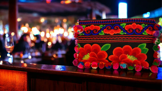 Cherry red blossom on licorice with multi-coloured pom pom clutch