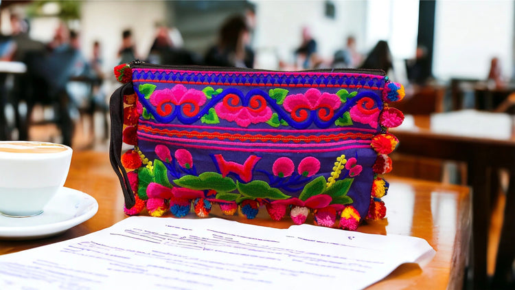 Pink and red blossom on electric blue with multi-coloured pom pom clutch